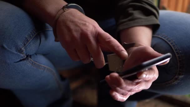 Hands in handcuffs scrolling on cellphone — Stock Video