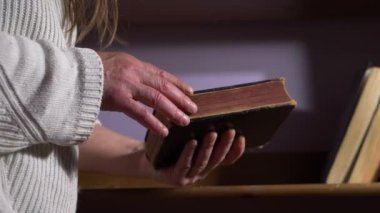 Eller eski bir kitabın sayfalarına bakıyor.