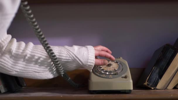 Frau wählt Nummer auf Oldtimer-Retro-Handy im Bücherregal — Stockvideo