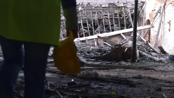 Trabajador caminando entre los escombros de un edificio demolido — Vídeo de stock