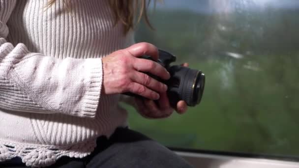Fotógrafo con cámara se sienta en la ventana — Vídeos de Stock