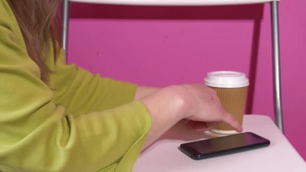 Kvinna som använder mobiltelefon med kaffe — Stockvideo