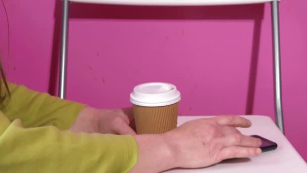 Mujer usando teléfono móvil con café en un escritorio — Vídeos de Stock