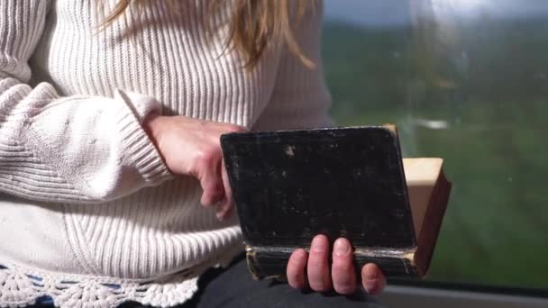 Frau genießt die Lektüre eines alten Buches im Fenster — Stockvideo
