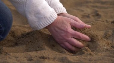 Kumsal kumları ellerinden düşüyor.