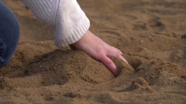 Hand smooths sand on the beach — Stock Video