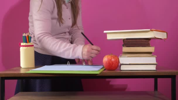 Teacher with books and apple marking homework — Stock Video