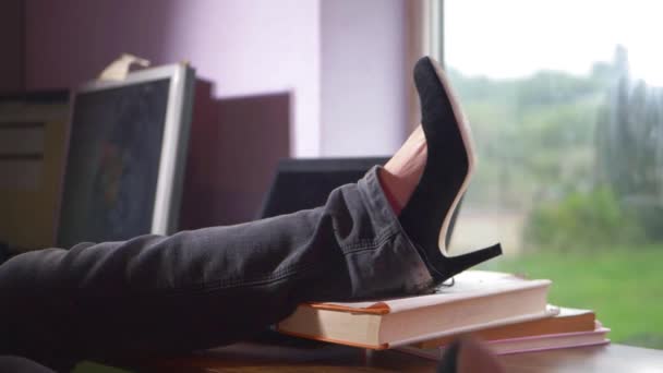 Woman puts feet up on desk at work — Vídeo de stock