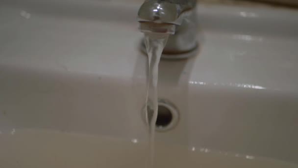 Flujos de agua del grifo del mezclador en el lavabo del baño — Vídeos de Stock