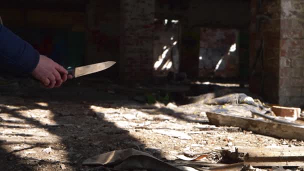 Verbrecher mit Messer wartet im Schatten verfallener Gebäude — Stockvideo