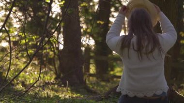 Ormanda hasır şapka takan bir kadın