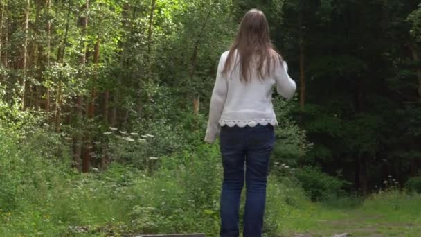 Γυναίκα κοιτάζει γύρω στο δάσος — Αρχείο Βίντεο