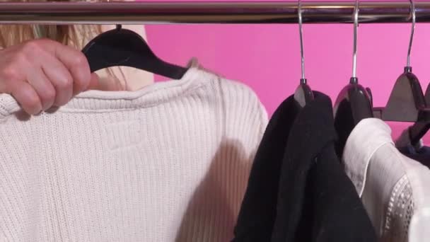 Comprador que escolhe de roupa em um trilho — Vídeo de Stock