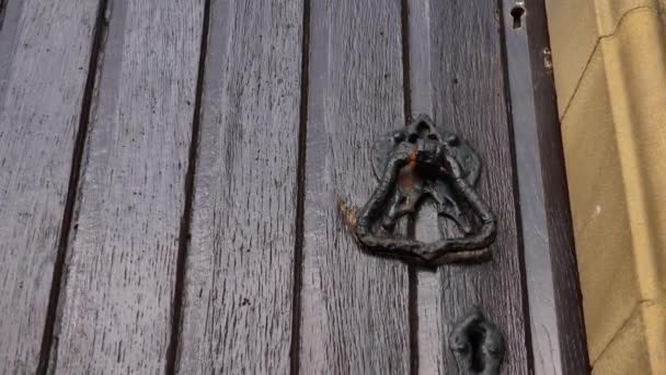 Maçaneta da porta na velha porta da igreja gótica se move ao vento — Vídeo de Stock
