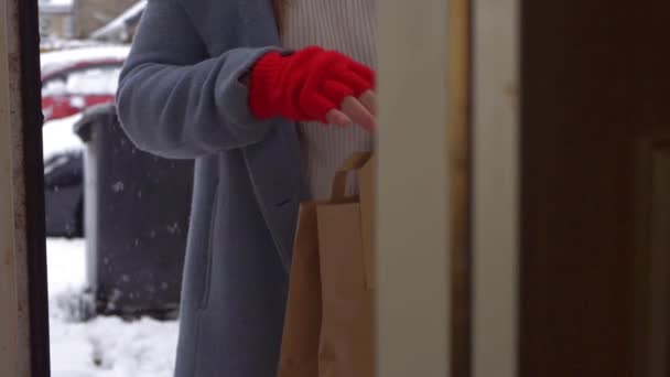 Abertura de porta para mulher com tirar a entrega de alimentos dia de inverno nevado — Vídeo de Stock
