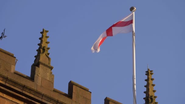 Англійський прапор Святого Георгія Хреста летить на даху церкви. — стокове відео