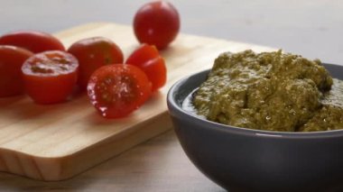 Kırmızı vişneli domates ve bir kase pesto.