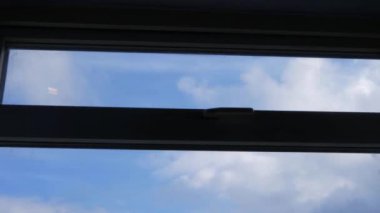 Mavi gökyüzünde pencereden geçen bulutların zaman akışı