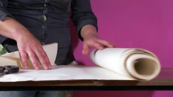 Rolling out forro de papel pintado sobre una mesa — Vídeos de Stock