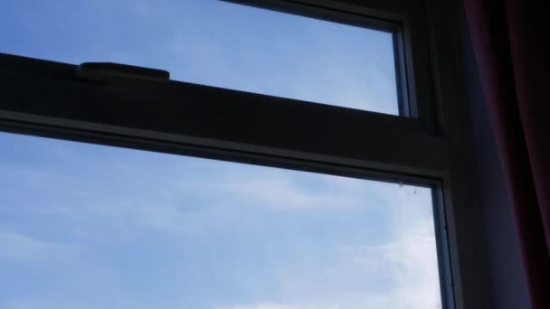 Time lapse of clouds passing across blue sky through view of window — Stock Video