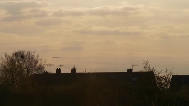 Timelapse al atardecer de nubes pasando por encima de las casas urbanas silueta — Vídeo de stock