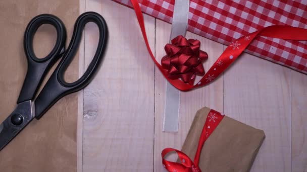 Scissors and Christmas wrapping paper on wooden background — Stock Video