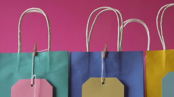 Ligne de sacs-cadeaux et étiquettes sur fond rose — Video