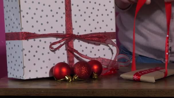 Περιτύλιγμα χριστουγεννιάτικα δώρα με κόκκινες κορδέλες — Αρχείο Βίντεο