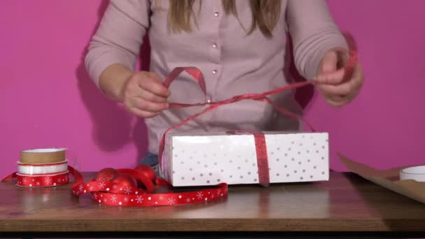 Envolver un regalo con lazo de cinta roja — Vídeos de Stock