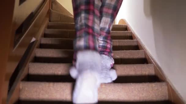 Kobieta wspina się po schodach, by iść spać. — Wideo stockowe