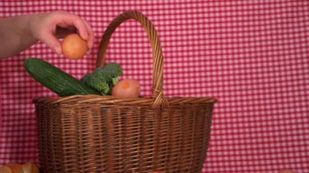 Підготовка кошика свіжої їжі на червоному тлі гінгема — стокове відео
