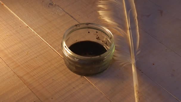Перо и чернила с мерцающим светом на столе — стоковое видео
