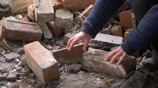 Руки, просеивающие обломки после катастрофы — стоковое видео