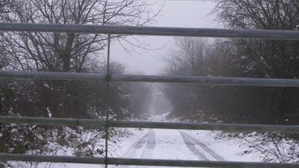 Route déserte après les chutes de neige en hiver à travers la vue de la porte — Video