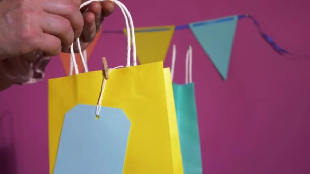 Chica de cumpleaños en busca de regalo en bolsa de colores en la fiesta — Vídeo de stock