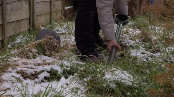 雪の冬の庭でフォークで掘る庭師 — ストック動画