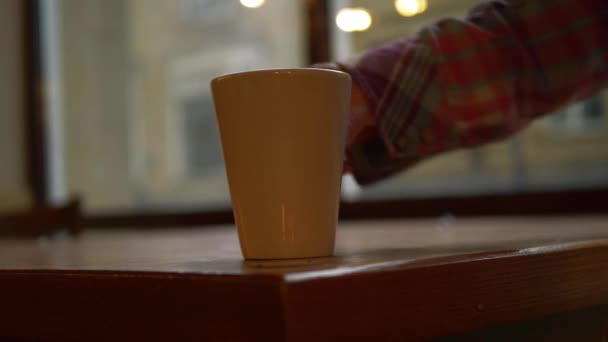 Ruce pití hrnek kávy v městské kavárně — Stock video