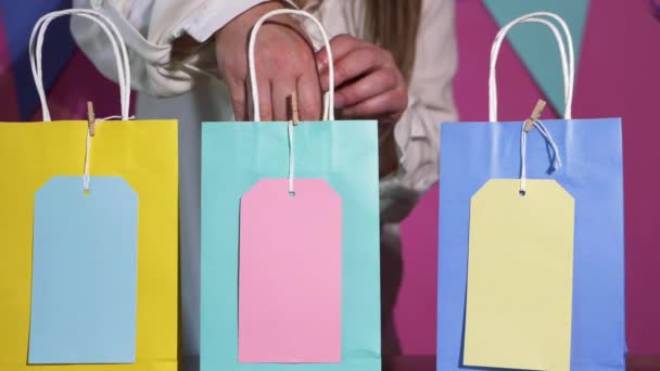 Menina de aniversário à procura de presente na fila de sacos coloridos — Vídeo de Stock