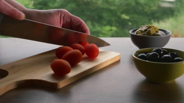 Picar tomates rojos cherry con aceitunas y pesto — Vídeos de Stock
