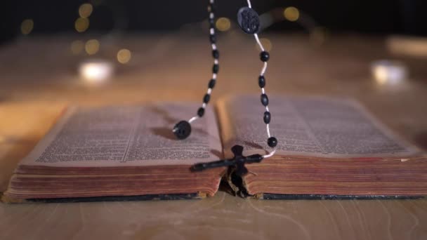 Χέρια τοποθετήστε κομπολόι χάντρες στη Βίβλο — Αρχείο Βίντεο