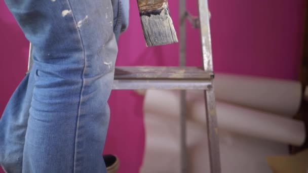 Naar beneden klimmen ladders met verf borstel versieren huis — Stockvideo