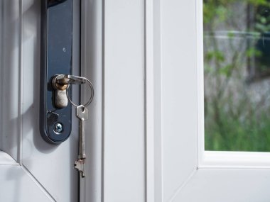 Anahtar kapalı kapıda, bahçeye bakıyor, seçici odak noktası.