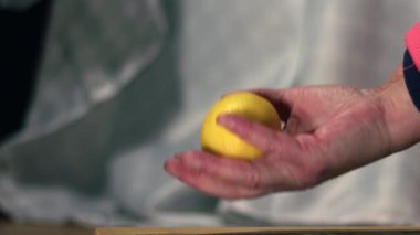 Kadın limon meyvesi fırlatır ve yakalar. Süper yavaş çekim seçici odak noktası.