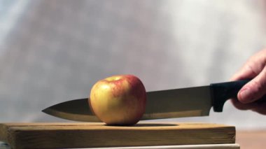 Keskin bir bıçakla elmayı ikiye bölmek süper yavaş çekimde seçici bir odak noktası.