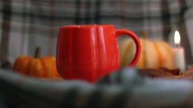Sıcak mum ışığında portakal kabağı çayı. Arka planda zoom yavaş çekim seçici odak noktası.