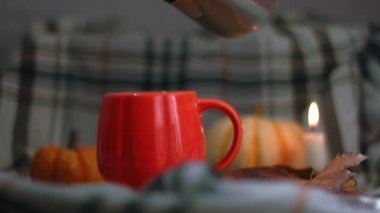Sıcak mum ışığında portakal kabağı çayı yapmak yavaş çekim seçici odak noktası