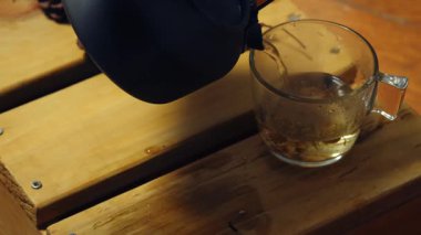 Çaydanlıktan papatya çayı yapmak. Orta boy zoom. Yavaş çekim seçici odaklanma.