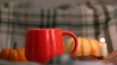 Sıcak mum ışığında portakal kabağı çayı. Arka planda zoom yavaş çekim seçici odak noktası.