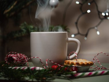 Noel süslemeleri olan bardakta sıcak içecek. Orta boy seçici odak noktası.