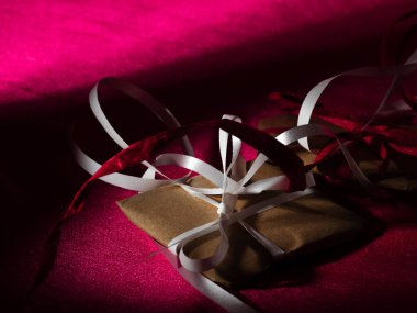 Pembe Sevgililer Günü hediyesi. Kırmızı arkaplan. Seçici odak noktasını kapat.